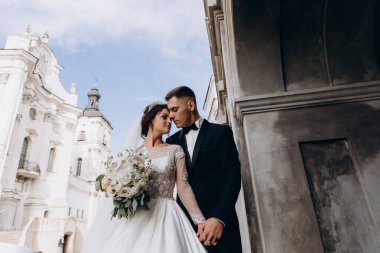 Güzel kilisenin yanında poz veren düğün çifti manzarası düşük açılı.