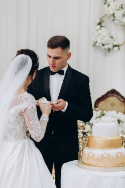 Mutlu gelin ve damat düğün pastasını kesiyor. 