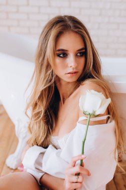 Beyaz küvetin yanında beyaz bir kadınla poz veren beyaz bir kadın. fotoğraf çekimi 