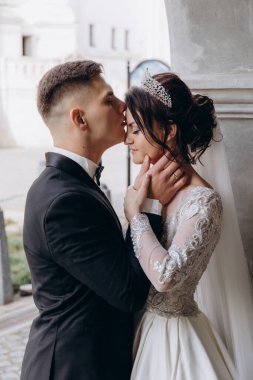 Güzel bir çift gelin ve damat düğün günü öpüşüyor.                    