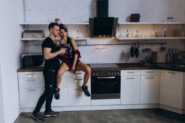 tutkulu çift mutfakta şarap içiyor.