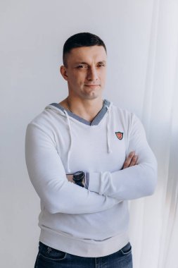 Stüdyoda poz veren sıradan kıyafetler giymiş genç yakışıklı bir adam. 