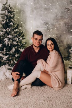Birbirlerine aşık genç bir çift stüdyoda rahat bir Noel süslemesiyle poz veriyorlar. Yeni yılın aşk hikayesi.. 