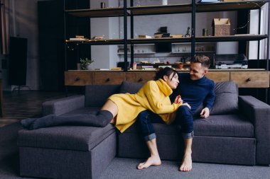 Mutlu genç çift evdeki oturma odasında birlikte vakit geçiriyor. 