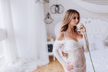 Stüdyoda beyaz gülle poz veren seksi bir kadın. fotoğraf çekimi 