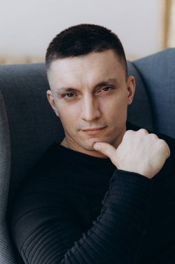 Stüdyoda poz veren sıradan kıyafetler giymiş genç yakışıklı bir adam. 