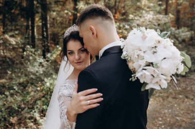 Gelin ve damat düğün günlerinde ormanda poz veriyorlar.