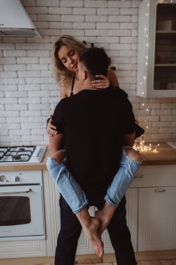 Güzel bir çift, arka planda Noel süsleriyle mutfakta şehvetle poz veriyor.