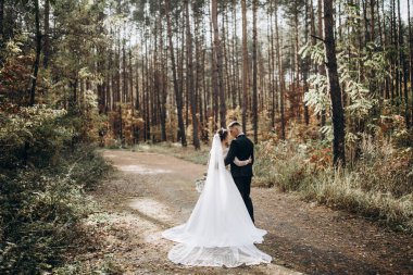 Güzel, mutlu, genç bir çift ormanda poz veriyor.                