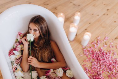 Stüdyoda beyaz küvette poz veren beyaz bir kadın. fotoğraf çekimi 