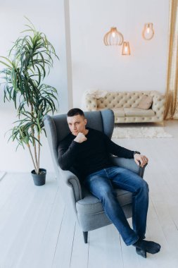 Genç adam stüdyoda poz verirken gündelik kıyafetler giyiyor.. 