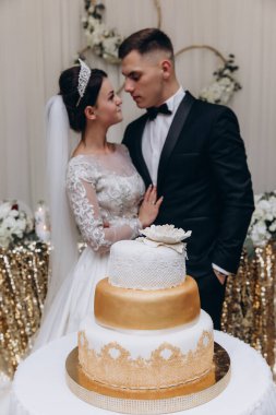 Bir restoranda düğün pastasıyla mutlu gelin ve damat    