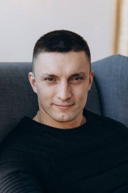 Stüdyoda poz veren sıradan kıyafetler giymiş genç yakışıklı bir adam. 