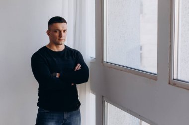 Stüdyoda poz veren sıradan kıyafetler giymiş genç yakışıklı bir adam. 