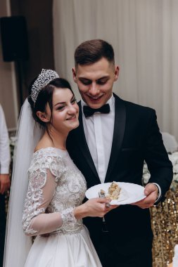 Bir restoranda düğün pastasıyla mutlu gelin ve damat    