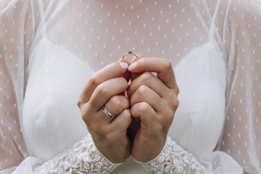 Yüzüğü elinde tutan genç gelinin yakın plan görüntüsü.