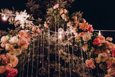 Açık hava düğün töreni için çiçeklerle süslenmiş güzel kemer manzarası.