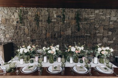 Güzel bir düğün masası. Restoranda mumlar ve çiçekler var.              