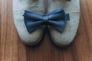 mavi papyon ve tahta arka planda ayakkabılar.