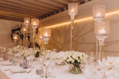 Güzel bir düğün masası. Restoranda mumlar ve çiçekler var.              