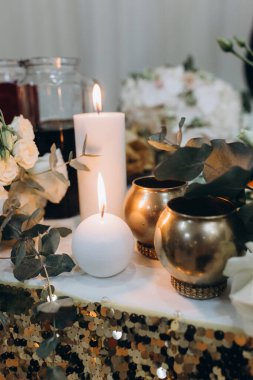 Çiçekler ve yanan mumlarla güzel düğün süslerinin yakın çekimi. 