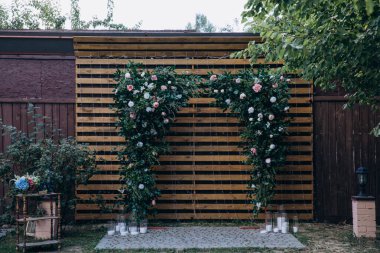 Parktaki açık hava töreni için çiçeklerle süslenmiş güzel bir düğün kemeri.     