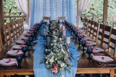 Güzel bir düğün masası. Restoranda mumlar ve çiçekler var.              