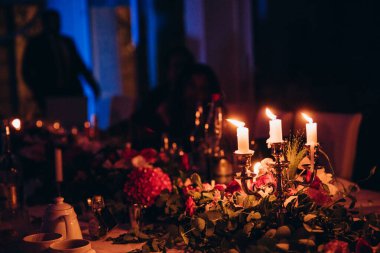 Düğün resepsiyonunda mum ve çiçeklerin yakın plan görüntüsü
