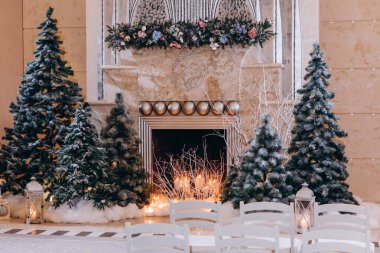 Noel süslemeleri, mumlar ve iç kısımda köknar ağaçları.