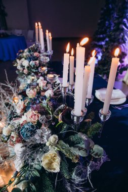 Güzel bir düğün masası. Restoranda mumlar ve çiçekler var.              