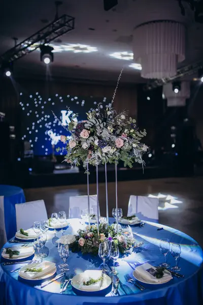 Çiçekli düğün masası ve mavi renkli ışıklar.