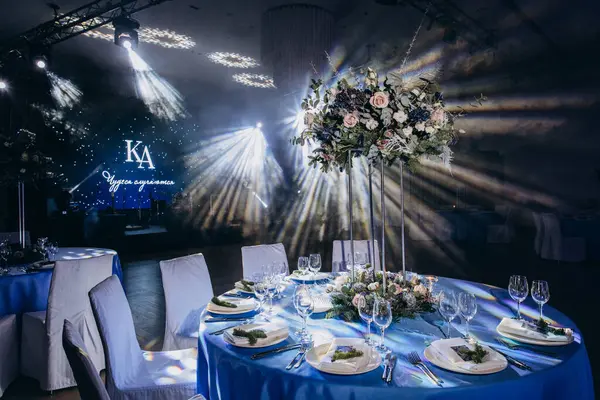 Çiçekli düğün masası ve mavi renkli ışıklar.