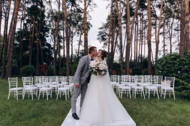 Güzel, mutlu, genç gelin ve damat açık havada evleniyor.