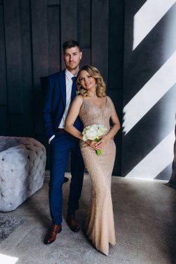 Güzel genç bir çift birlikte poz veriyor ve kameraya gülümsüyor.