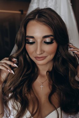 Beyaz iç çamaşırlı, ipek cüppeli ve peçeli çekici gelin sabahları evde gelinlikle poz veriyor.            