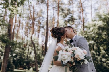 Mutlu genç gelin ve damat parkta öpüşme              