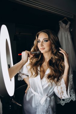 Genç gelin düğün makyajı yapıyor.