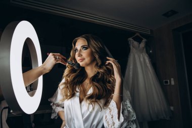 Genç gelin düğün makyajı yapıyor.