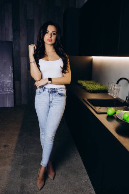 Çatı katında poz veren gündelik elbiseli genç bir kadın.