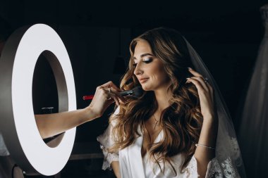 Genç gelin düğün makyajı yapıyor.