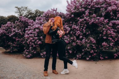 Mutlu çift baharda parkta poz veriyor. 