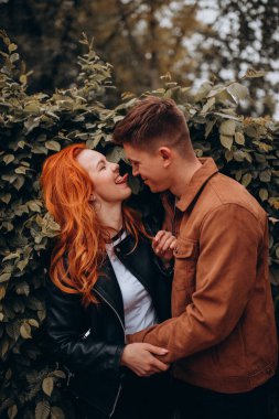 Genç ve güzel bir çift sonbahar parkında poz veriyor. 