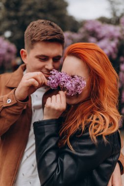 Mutlu çift baharda parkta poz veriyor. 