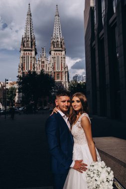 Güzel, genç, mutlu gelin ve damat düğün gününde şehirde         