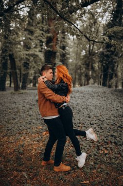 Güz parkında poz veren genç ve güzel bir çift.