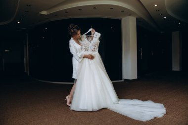 Güzel mutlu genç gelinin portresi zarif bir gelinlik tutuyor.          