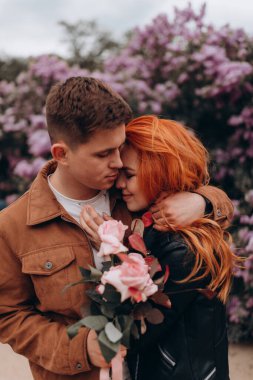 Mutlu çift baharda parkta poz veriyor. 