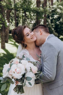 Mutlu genç gelin ve damat parkta öpüşme              