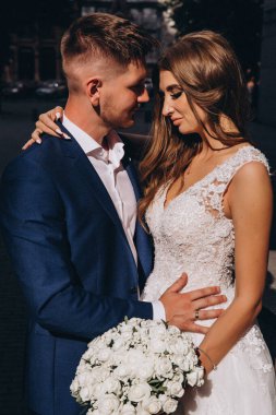 Güzel, genç, mutlu gelin ve damat düğün gününde şehirde         