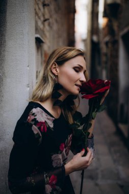 Kırmızı gülle poz veren kadın